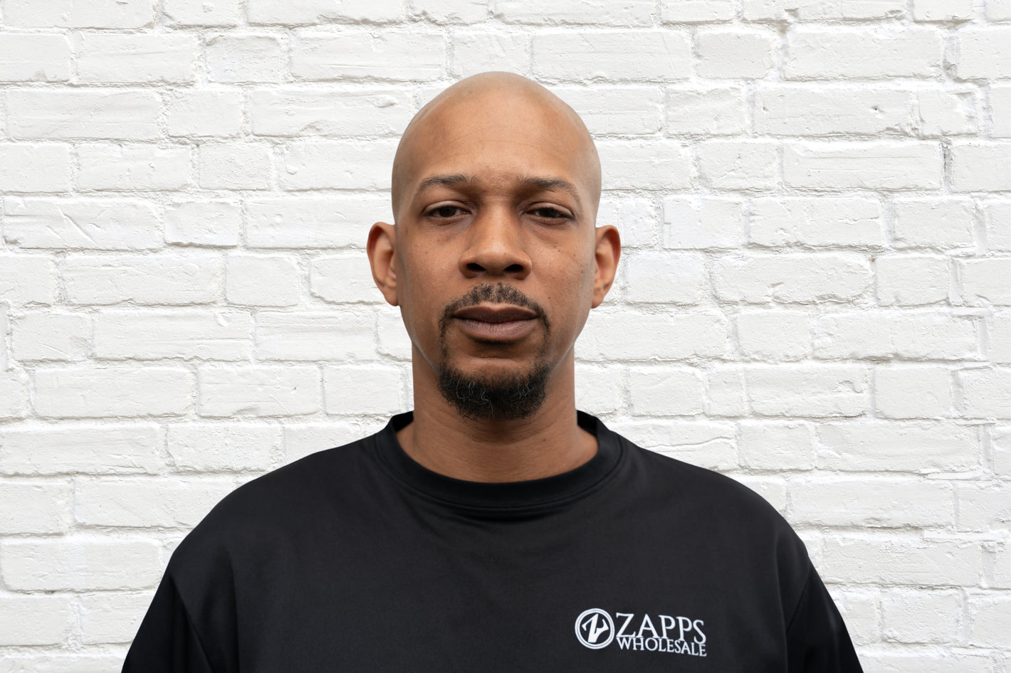 Alex, Operations Team member of leading wholesale liquidation company in the United States, Zapps Wholesale, poses in North Carolina warehouse.